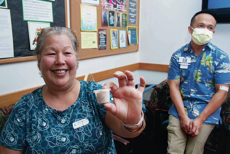 CRAIG T. KOJIMA / CKOJIMA@STARADVERTISER.COM
                                Dr. Cedric Lorenzo, right, medical director of Queen’s Comprehensive Weight Management Program, with patient Carol Ohelo at the Punchbowl campus Thursday as Ohelo shows a food portion equal to her stomach size.
