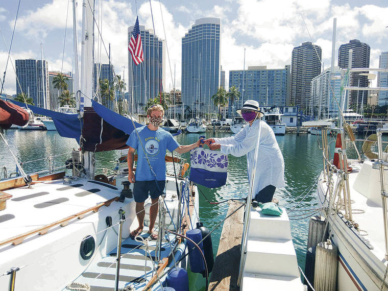 LEE CATALUNA / LCATALUNA@STARADVERTISER.COM
                                Milosz Kaczorowski, left, captain of the Golden Rule, has obeyed the 14-day quarantine aboard the sailboat with help from Barbara Cooney and other supporters, who brought him food and ice while maintaining social distancing.