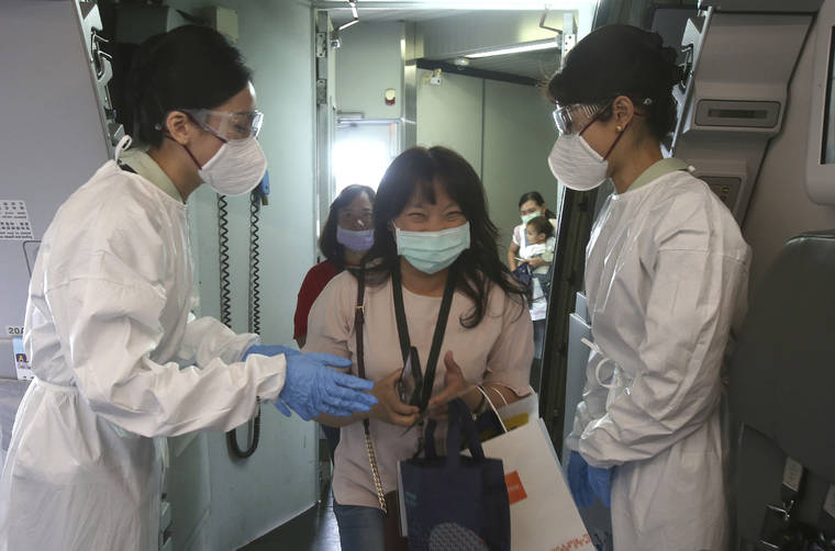 ASSOCIATED PRESS
                                Participants are greeted by flight attendants in protective suits during a mock trip abroad at Taipei Songshan Airport in Taipei, Taiwan, Tuesday. Dozens of would-be travelers acted as passengers in an activity organized by Taiwan’s Civil Aviation Administration to raise awareness of procedures to follow when passing through customs and boarding their plane at Taipei International Airport.
