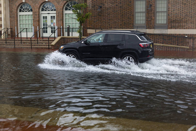 KRISTIAN GONYEA/THE PRESS OF ATLANTIC CITY VIA AP
                                A sport utility vehicle moves down a flooded street in Ventnor, N.J. Fast-moving Tropical Storm Fay made landfall in New Jersey on Friday amid heavy, lashing rains that closed beaches and flooded shore town streets.