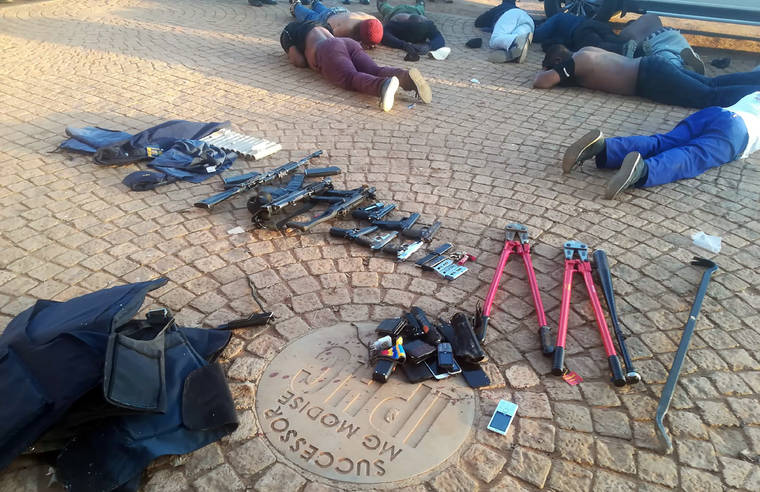 SOUTH AFRICAN POLICE SERVICES VIA AP
                                Confiscated arms and ammunition, foreground, and arrested suspects, background, lay face-down at a church in Zuurbekom, near Johannesburg. Police in South Africa say five people are dead and more than 40 have been arrested after an early-morning hostage situation at a church near Johannesburg.