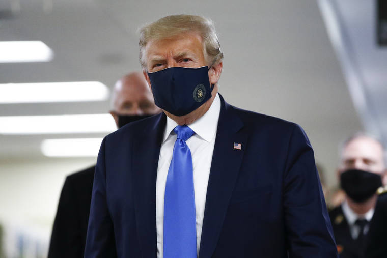 ASSOCIATED PRESS
                                President Donald Trump wears a mask as he walks down the hallway during his visit to Walter Reed National Military Medical Center in Bethesda, Md.