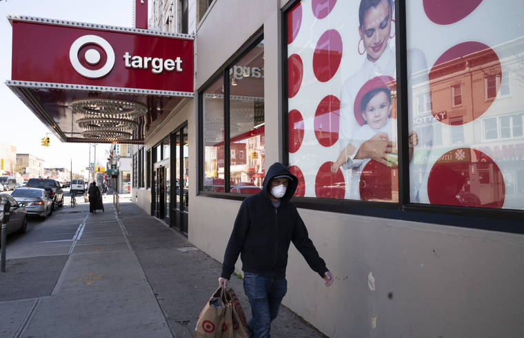 ASSOCIATED PRESS
                                A customer wearing a mask carried his purchases, April 6, as he left a Target store during the coronavirus pandemic in the Brooklyn borough of New York. Target has joined a growing list of major retailers that will require customers at all their stores to wear face coverings.