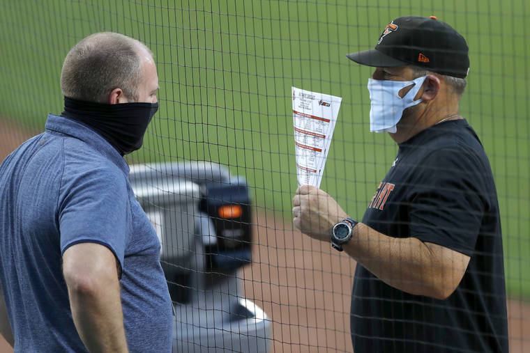 ASSOCIATED PRESS
                                Baltimore Orioles director of baseball administration Kevin Buck, left, and field coordinator Tim Cossins wore masks to protect against COVID-19 as they talked during an intrasquad game at baseball training camp, Tuesday, in Baltimore.