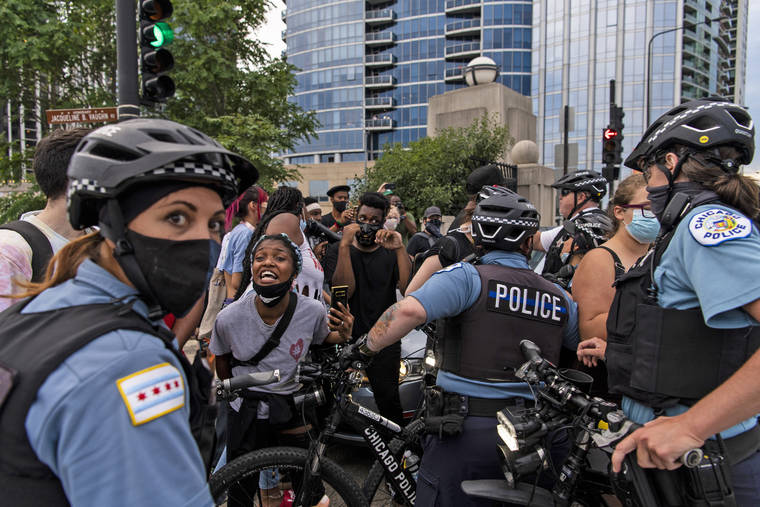 TYLER LARIVIERE/CHICAGO SUN-TIMES VIA ASSOCIATED PRESS
                                Chicago police and activists crowded around a vehicle that tried to drive through the circle of protesters at the intersection of Roosevelt Rd. and Columbus Dr, Monday, in Chicago.