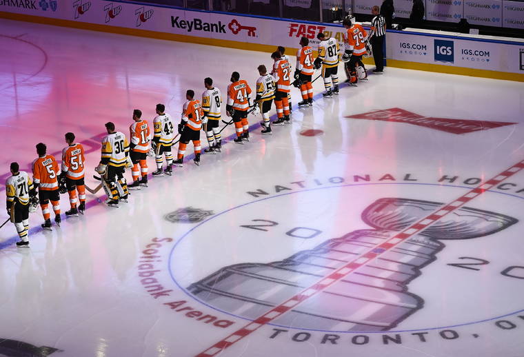 ASSOCIATED PRESS
                                The Pittsburgh Penguins and Philadelphia Flyers line up together for the national anthems before an exhibition NHL hockey game today in Toronto.
