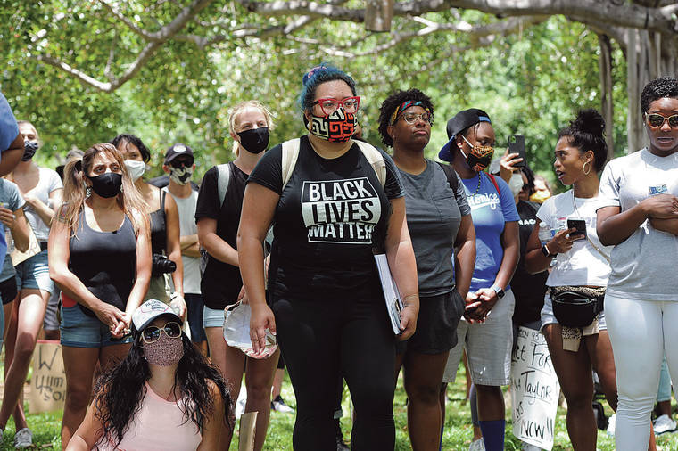 STAR-ADVERTISER / JUNE 14
                                Shayna Lonoaea-Alexander listened to speakers with a Black Lives Matter t-shirt during a peaceful protest in Honolulu.