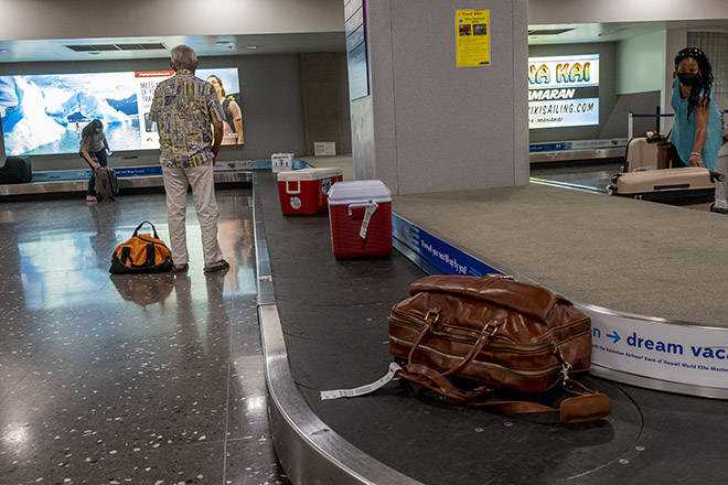 DENNIS ODA / STAR-ADVERTISER
                                Travelers waited to collect their luggage, June 24, at Daniel K. Inouye International Airport. The Hawaii Tourism Authority reported today that visitor arrivals to Hawaii in June fell to 17,068, a 98% decrease from the same month last year.