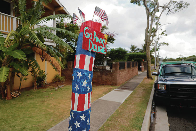 A painted tree stump, left, was seen along Hawaii Kai Drive Saturday wishing the hurricane would not hit the islands.