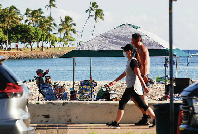 CINDY ELLEN RUSSELL / CRUSSELL@STARADVERTISER.COM
                                A family relaxed in the shade of a tent as walkers exercised at Ala Moana Regional Park on Wednesday. The state has seen a surge in COVID-19 cases in the past week.