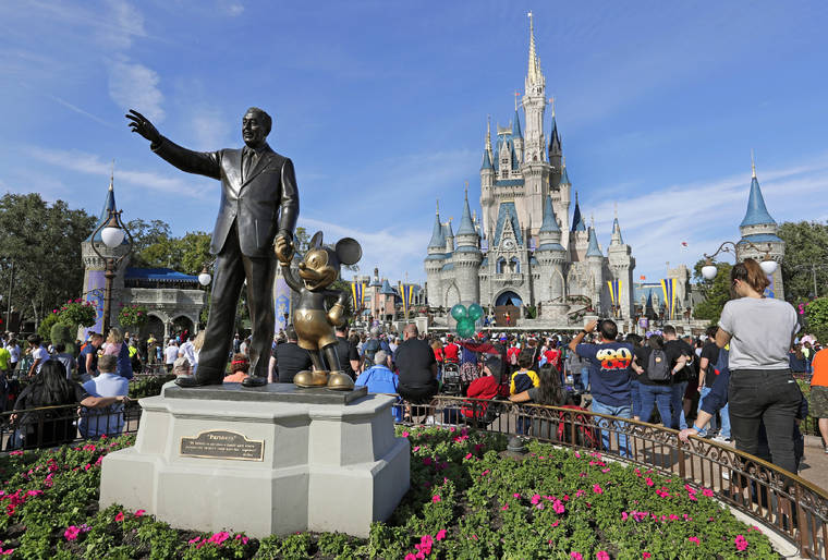 ASSOCIATED PRESS
                                Guests watch a show near a statue of Walt Disney and Micky Mouse in front of the Cinderella Castle at the Magic Kingdom at Walt Disney World in Lake Buena Vista in 2019.