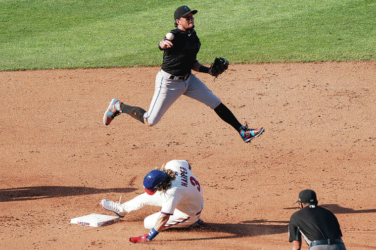 ASSOCIATED PRESS
                                Miami shortstop Miguel Rojas jumped over Philadelphia’s Bryce Harper as he turned a double play during a game on Saturday in Philadelphia.