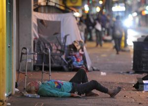 BRUCE ASATO / BASATO@STARADVERTISER.COM
                                A man lies down on a N. Hotel St. sidewalk as night falls.