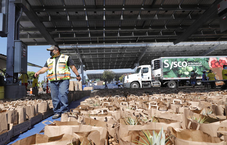 STAR-ADVERTISER
                                Brian Miyamoto, executive director of the Hawaii Farm Bureau, walked by hundreds of bagged produce items readied for distribution, May 8, during the Ohana Food Distribution and food drive at Leeward Community College in Pearl City.