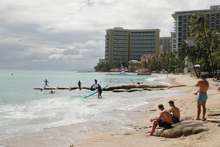 JAMM AQUINO / JAQUINO@STARADVERTISER.COM 
                                With visitor arrivals continuing to nose-dive, Hawaii’s economic outlook looks grim. Beachgoers enjoyed the ocean Thursday at a sparsely crowded Waikiki Beach.