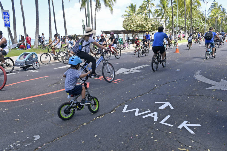 BRUCE ASATO / JUNE 28
                                Bicyclists, walkers and joggers along Kalakaua Avenue for Kalakaua Open Street Sunday in Waikiki. The event has been canceled this weekend.