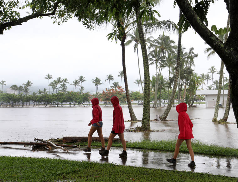 TIM WRIGHT / SPECIAL TO THE STAR-ADVERTISER
                                Three visitors survey Hilo’s flooded Bayfront as Hurricane Lane dumped over 30 inches of rain on Aug. 24, 2018.