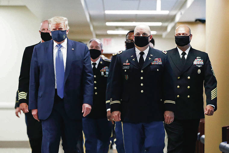 ASSOCIATED PRESS
                                President Donald Trump, foreground left, wears a face mask as he walks with others down a hallway during a visit to Walter Reed National Military Medical Center in Bethesda, Md., on July 11.