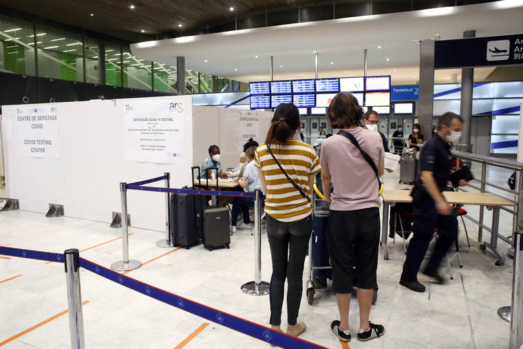ASSOCIATED PRESS
                                People register prior to be tested with the COVID-19 test, at the Roissy Charles de Gaulle airport, outside Paris. Travelers entering France from 16 countries where the coronavirus is circulating widely are having to undergo virus tests upon arrival at French airports and ports.