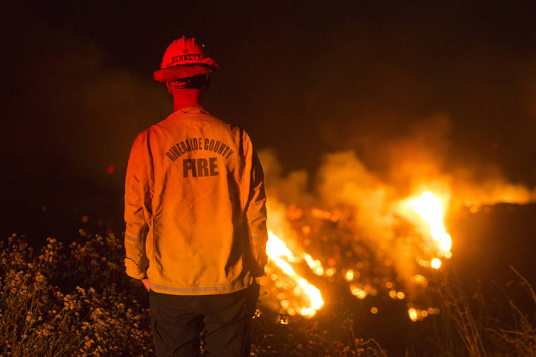 ASSOCIATED PRESS
                                A firefighter watches a brush fire at the Apple Fire in Banning, Calif., on Saturday.
