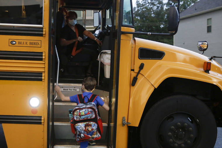 ASSOCIATED PRESS
                                Paul Adamus, 7, climbed the stairs of a bus before the first day of school, today, in Dallas, Ga. Adamus is among tens of thousands of students in Georgia and across the nation who were set to resume in-person school today for the first time since March.
