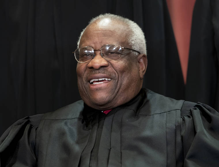ASSOCIATED PRESS
                                Supreme Court Associate Justice Clarence Thomas, appointed by President George H. W. Bush, sits with fellow Supreme Court justices for a group portrait at the Supreme Court Building in Washington in 2018. Thomas has never been afraid to turn right when his colleagues turn left, or in any direction really as long as there’s a place to plug in his 40-foot refitted tour bus.