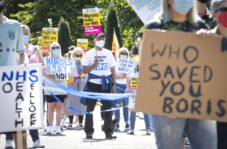 ASSOCIATED PRESS
                                National Health Service (NHS) workers pose with placards, during a socially distanced demonstration as part of a national protest over pay, in Glasgow, Scotland, today. Nationwide protests are calling for government to address what they claim is many years of reduced wages, and are calling for a voice in plans for public sector pay increases.