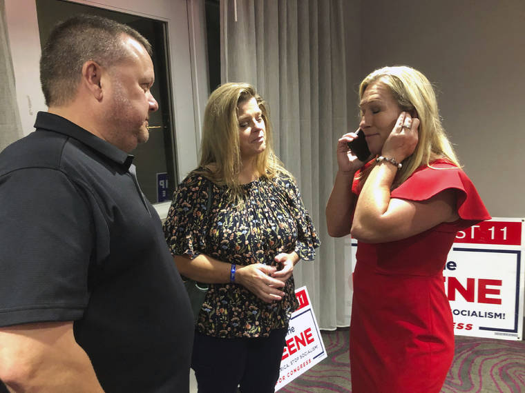 ASSOCIATED PRESS
                                Supporters stood with construction executive Marjorie Taylor Greene, right, as she spoke on the phone, late Tuesday, in Rome, Ga. Greene, criticized for promoting racist videos and adamantly supporting the far-right QAnon conspiracy theory, won the GOP nomination for northwest Georgia’s 14th Congressional District.