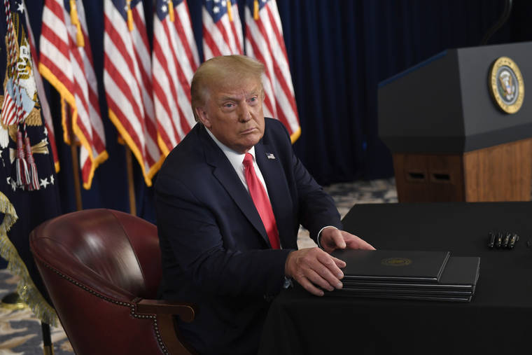 ASSOCIATED PRESS
                                President Donald Trump prepares to sign four executive orders during a news conference at the Trump National Golf Club in Bedminster, N.J., on Saturday.