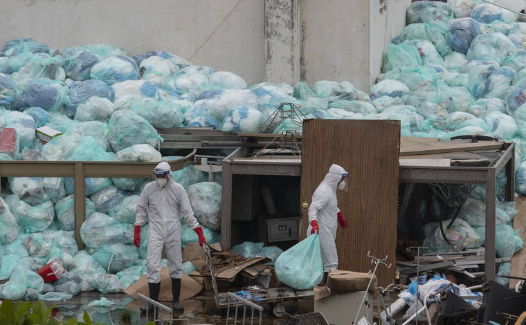 ASSOCIATED PRESS
                                Medical workers using protective equipment dispose of trash bags containing hazardous biological waste into a large pile outside the Hospital del Instituto Mexicano del Seguro Social, which treats patients with COVID-19 in Veracruz, Mexico, today. Improper disposal of medical waste has become an increasing problem in Mexico amid the pandemic.