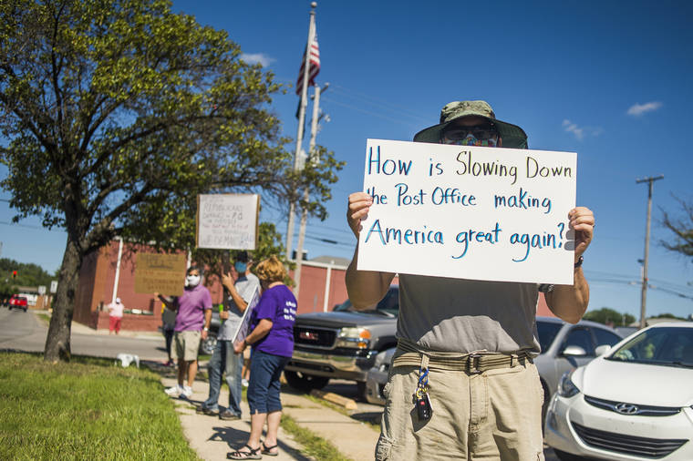 Katy Kildee/Midland Daily News via ASSOCIATED PRESS
                                Eric Severson held a sign as a few dozen people gathered in front of the United States Post Office on Rodd St. to protest recent changes to the U.S. Postal Service under new Postmaster General Louis DeJoy, Tuesday, in Midland, Mich.