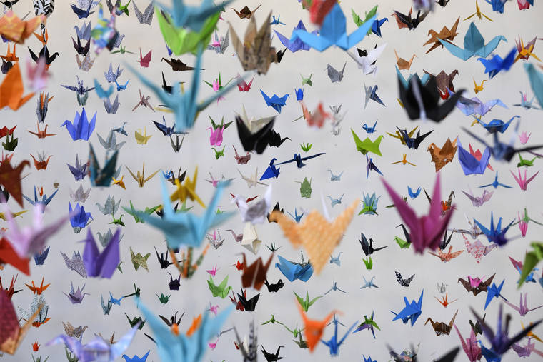 ASSOCIATED PRESS
                                Origami paper cranes hung in the Matter Studio Gallery in Los Angeles during an exhibit for those who have died in the U.S. of COVID-19, on Tuesday. Hundreds of origami now hang from the ceiling of Karla Funderburk’s Matter Studio with others sitting on tables and stacked in boxes waiting to be added to the sad reminder of the virus’ toll.