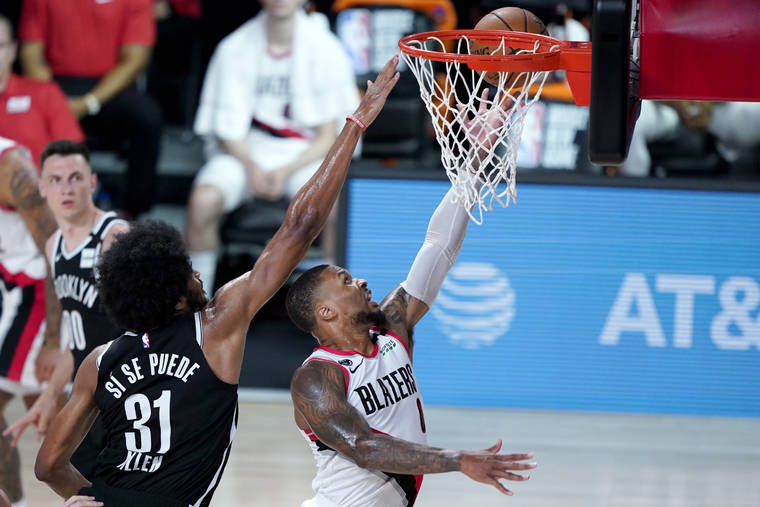 ASSOCIATED PRESS
                                Portland Trail Blazers’ Damian Lillard, right, goes up for a shot against Brooklyn Nets’ Jarrett Allen (31) during the first half of an NBA basketball game today in Lake Buena Vista, Fla.