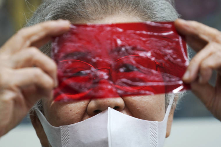 ASSOCIATED PRESS
                                Kisako Motoki, 86, speaks, looking though a red cellophane depicting what she saw the atmosphere of the night of the Great Tokyo Air Raid on March 10, 1945, during an interview with the Associated Press at the Center for the Tokyo Raids and War Damage in Tokyo.