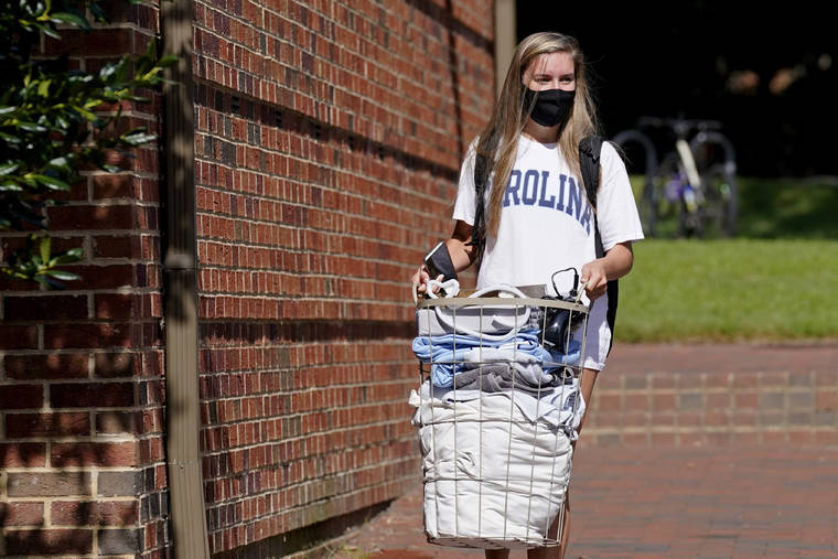 ASSOCIATED PRESS
                                Freshman Sarah Anne Cook carried her belongings as she packed to leave campus following a cluster of COVID-19 cases at the University of North Carolina in Chapel Hill, N.C., Tuesday. The university announced that it would cancel all in-person undergraduate learning starting today while some students chose to pack and leave.