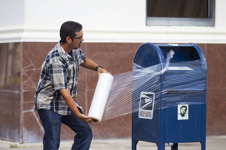 MARK MULLIGAN/HOUSTON CHRONICLE VIA ASSOCIATED PRESS
                                A United States Postal Service Employee covered a mailbox with plastic wrap after removing the last mail from it as the island prepared for possible impact from Hurricane Laura, Tuesday, in Galveston. The plastic wrap signals that the final mail has been cleared from the box and prevents people from placing more mail inside in case of flooding.