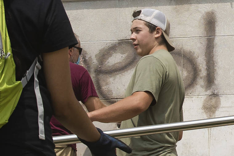 CHICAGO SUN-TIMES VIA AP
                                Kyle Rittenhouse helps clean the exterior of Reuther Central High School in Kenosha, Wis., on Tuesday. Rittenhouse, 17, was arrested Wednesday after two people were shot to death during protests in Kenosha over the police shooting of Jacob Blake.