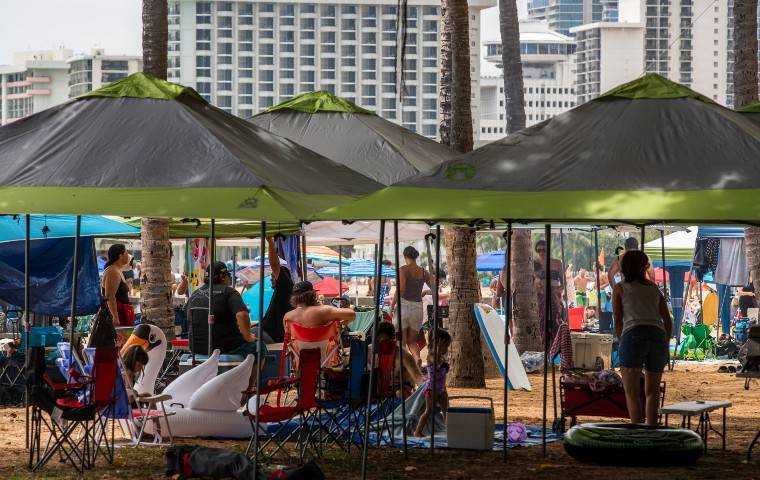 CINDY ELLEN RUSSELL / JULY 4
Tents, umbrellas and people packed the shore near Walls on the Fourth of July in Waikiki. Department of Health officials have attributed household COVID-19 clusters to social interactions such as gatherings on the Fourth of July. 