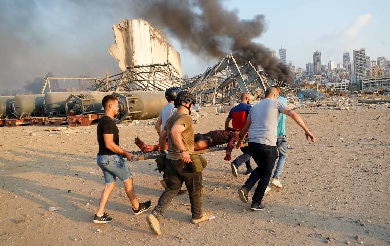 ASSOCIATED PRESS
                                Civilians carried a victim at the explosion scene that hit the seaport, in Beirut, Lebanon, today. Massive explosions rocked downtown Beirut today, flattening much of the port, damaging buildings and blowing out windows and doors as a giant mushroom cloud rose above the capital.
