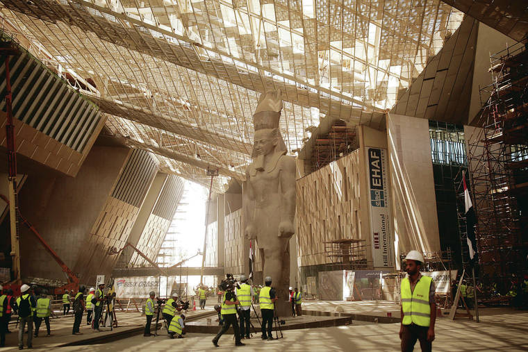 ASSOCIATED PRESS 
                                Construction workers and journalists gather at the Grand Egyptian Museum under construction in Giza, Egypt, near Cairo, in August 2019. For the first time, the gold-covered sarcophagus of famed boy pharaoh Tutankhamun will be restored, ahead of the new museum’s opening, set for 2021. At top, the empty Giza Pyramids and Sphinx complex during the coronavirus lockdown in March. Below, a cheetah prowls the Namib desert, Namibia.