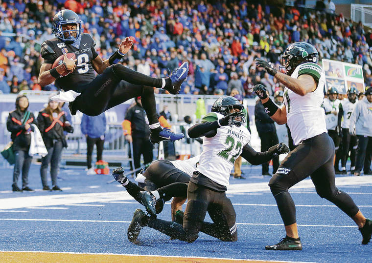 ASSOCIATED PRESS
                                Boise State quarterback Jaylon Henderson, left, went airborne over Hawaii defensive back Khoury Bethley, middle, and Hawaii defensive back Ikem Okeke (22) for a 5-yard touchdown during the Mountain West Championship game on Dec. 7 in Boise, Idaho.