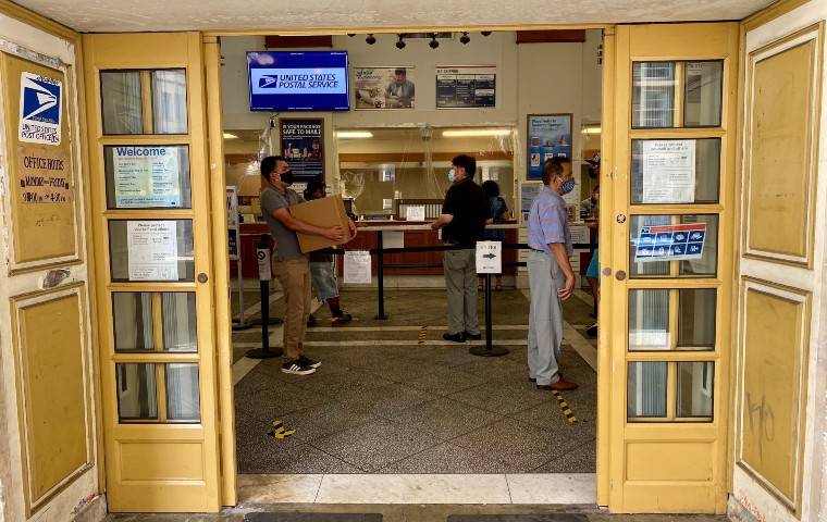 DIANE LEE / DLEE@STARADVERTISER.COM
                                People practicing social distancing waited in line, Aug. 6, to mail packages and letters at the downtown Honolulu post office on Merchant Street.