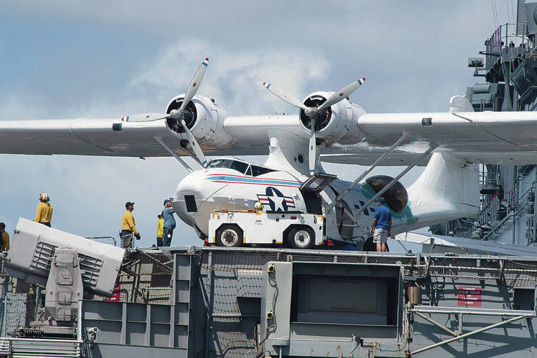 CRAIG T. KOJIMA / CKOJIMA@STARADVERTISER.COM
                                A Consolidated/Boeing Canada PBY Catalina was prepped to be lifted off the deck of the USS Essex on Aug. 11 at Pearl Harbor to take part in the “Legacy of Peace” aerial parades that are part of the events commemorating the 75th anniversary of the end of WWII.