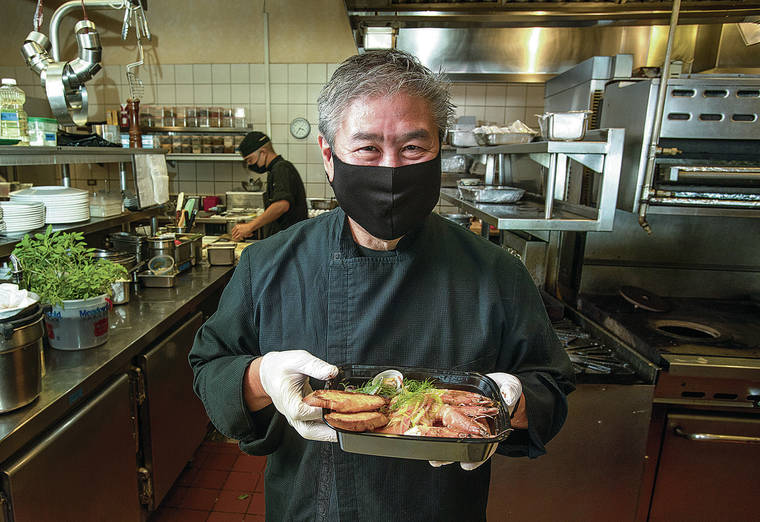 CINDY ELLEN RUSSELL / CRUSSELL@STARADVERTISER.COM
                                A masked-up chef Alan Wong holds a seafood soup that was part of the upscale takeout menu he’d been offering.