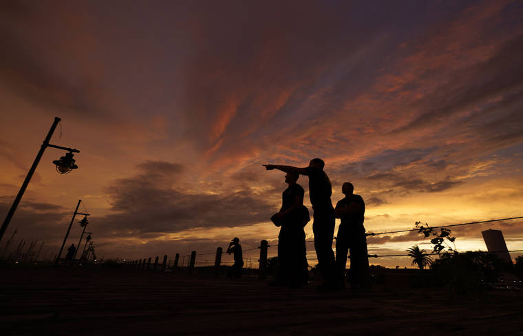 ASSOCIATED PRESS
                                Port Arthur firefighters star on a sea wall at sunset as they wait for Hurricane Laura to make landfall today in Port Arthur, Texas.