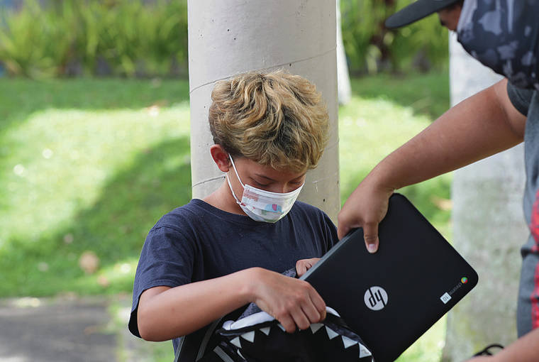 CINDY ELLEN RUSSELL / CRUSSELL@STARADVERTISER.COM
                                Kainoa Chung, 10, collected a laptop from fifth grade teacher Jared Yim as well as other supplies during the first day of the academic year at Royal Elementary School on Monday.