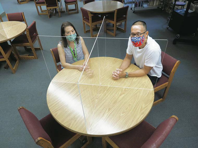 MID-PACIFIC INSTITUTE
                                Mid-Pacific’s Anne Young, circulation clerk, and David Wee, director of library and media services, demonstrate the new Plexiglas table dividers in Kawaiaha‘o Library.