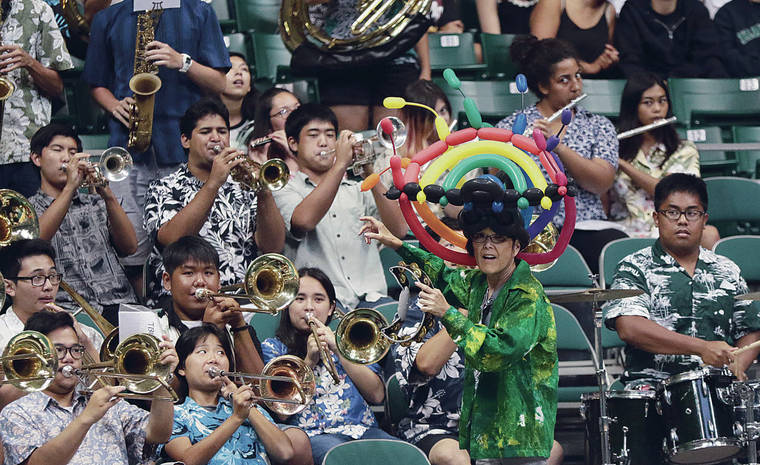 KRYSTLE MARCELLUS / 2015 
                                UH band conductor Gwen Nakamura got in the spirit during a Wahine volleyball match at the Stan Sheriff Center. Even with Zoom meetings, Nakamura said that “nothing is the same as doing it in person.”