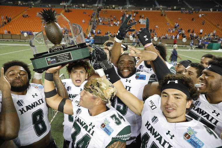 JAMM AQUINO / JAQUINO@STARADVERTISER.COM
                                The Hawaii Rainbow Warriors raise the 2019 SoFi Hawaii Bowl trophy after winning against the Brigham Young Cougars on Dec. 24.