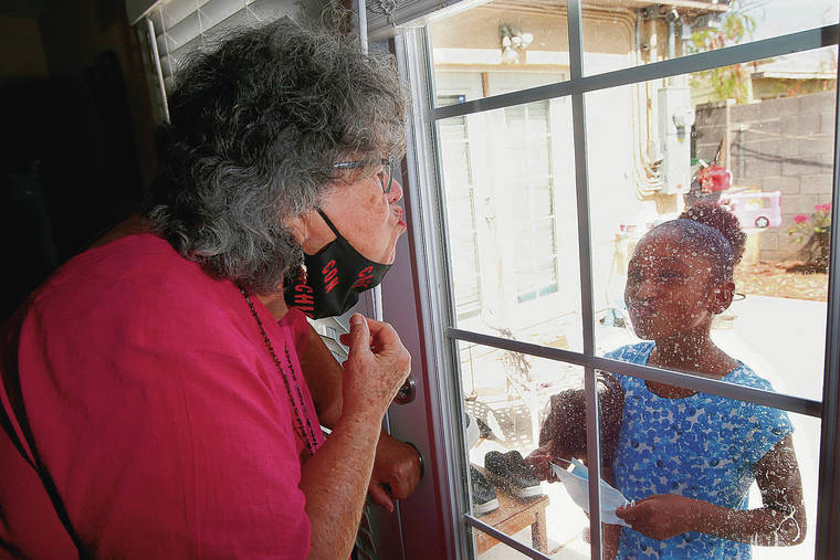 ASSOCIATED PRESS 
                                Zita Robinson, who’s 77 and diabetic, blows a kiss to her granddaughter Traris “Trary” Robinson-Newman, 8, who blows a kiss back to her in Phoenix.